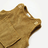 Close-up of mustard baby corduroy overalls with wooden button detail